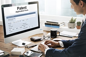 Man at desk looking at medical patent application online